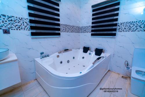贝宁城Gillant Luxury Homes的浴室设有白色浴缸,铺有黑白瓷砖。