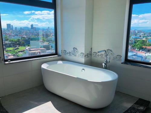 岘港Mercury Beach DaNang的带窗户的浴室内的白色浴缸