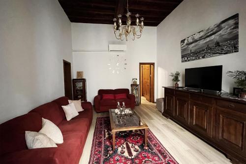 佛罗伦萨Da Mario in Florence Guesthouse的客厅配有红色沙发和平面电视