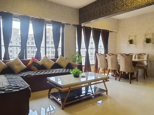孟买OSI Apartments Khar West的客厅配有沙发和桌子