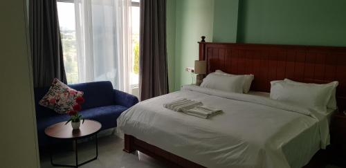 多多马Eastern City Hotel的一间卧室配有一张大床和一张蓝色椅子