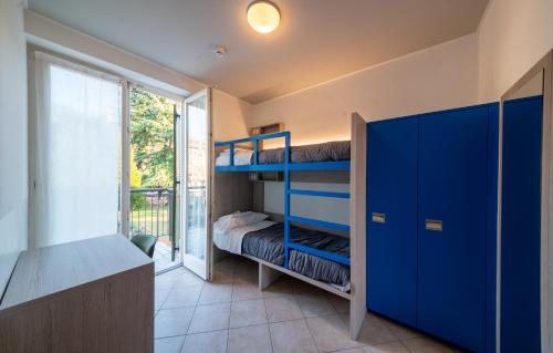 罗韦雷托Ostello Città di Rovereto的一间卧室设有蓝色双层床和窗户。