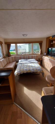 斯凯格内斯Springs 46 by Vilija Southview Leisure Park Skegness的船上的卧室,配有床和沙发