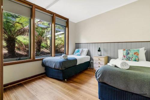 DoverThe Beach House- private jacuzzi and wood fire!的一间卧室设有两张床和窗户。