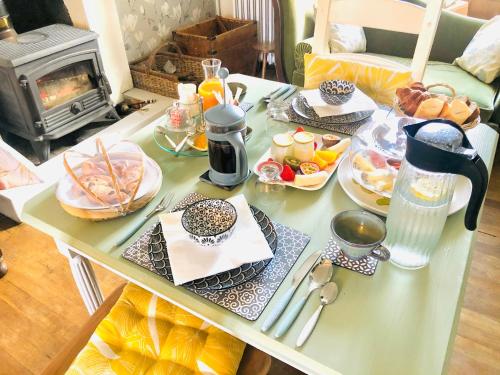 普洛默迪耶尔恩Maison Papillons的一张带早餐食品的桌子,上面有炉灶