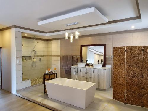 MatsaphaGoggas Nest BNB & Restaurant的大型浴室设有浴缸和淋浴。