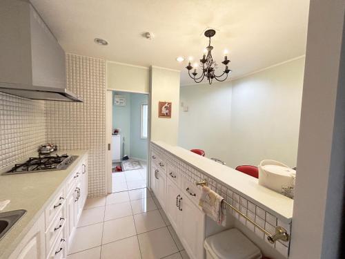 恩纳银河海洋度假公寓 的厨房配有白色橱柜和吊灯。
