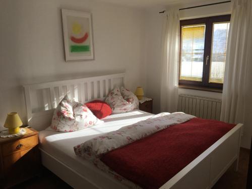 蒙德塞Ferienwohnung Meindl Elfi An der Drachenwand 44的卧室配有白色的床、红色床单和枕头