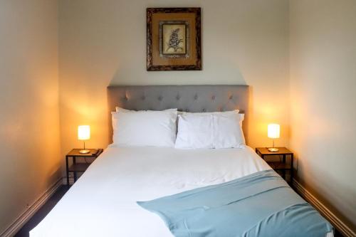 温莎Tates Hotel Windsor的一间卧室,两边都配有一张床和两盏灯