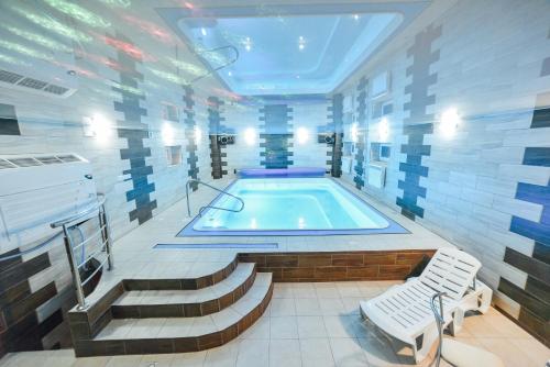 特鲁斯卡韦茨茉莉SPA别墅的游泳池位于带楼梯和浴缸的客房