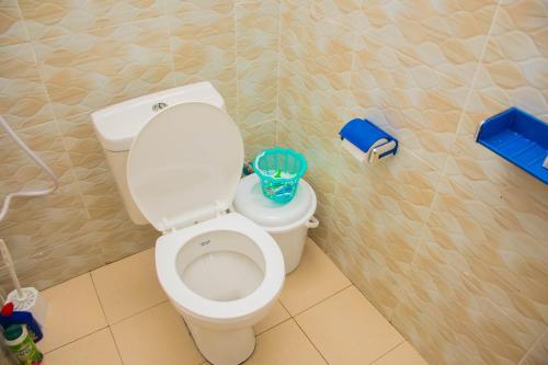 蒙巴萨IWACU-Cosy,Spacious 1 Bedroom Apartment along Nyali Road的浴室设有白色卫生间和蓝色篮子。