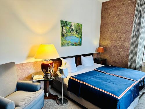 拉德博伊尔ZU DEN LINDEN - RADEBEUL Pension mit Restaurant的酒店客房,配有床和沙发