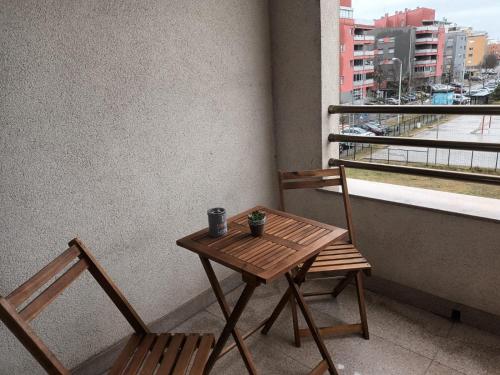 萨格勒布Odmor u Zagrebu的阳台上配有一张木桌和两把椅子