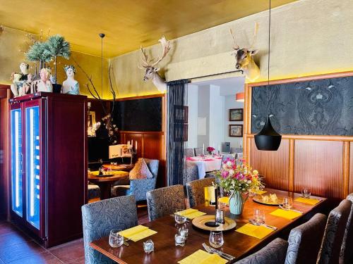 拉德博伊尔ZU DEN LINDEN - RADEBEUL Pension mit Restaurant的墙上设有桌椅和鹿头的餐厅