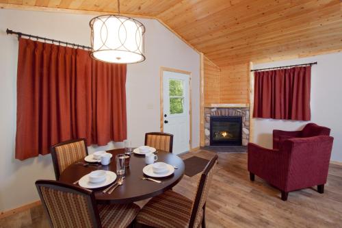 贾斯珀东碧玉山林小屋的一间带桌椅和壁炉的用餐室