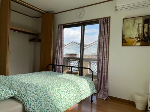 大阪Guest House Kubo Homes Matsu的一间卧室设有一张床和一个大窗户