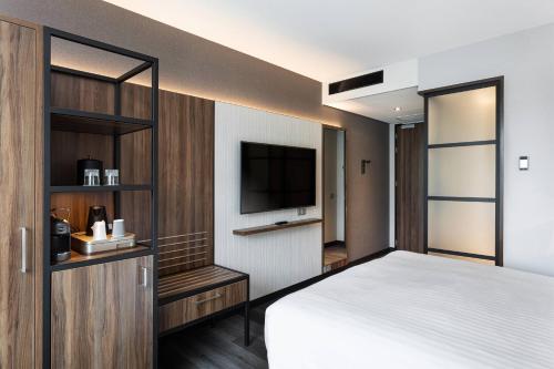 霍夫多普阿姆斯特丹机场万怡酒店的一间卧室配有一张床和一台平面电视