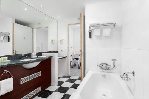 霍夫多普阿姆斯特丹机场万怡酒店的带浴缸和盥洗盆的浴室