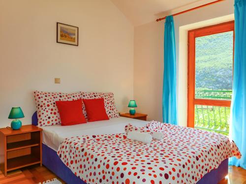 PodšpiljeHouse Podaspilje Omis的卧室设有红色和白色的床和窗户。