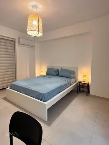 圣多明各Hermoso refugio céntrico的一间卧室配有一张带蓝色床单和一盏灯的床。