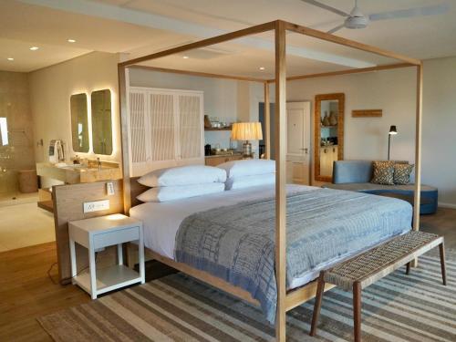巴利托Sala Beach House的一间卧室设有一张大天蓬床和一间浴室。
