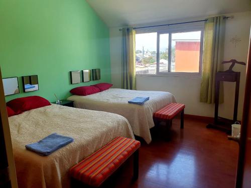 危地马拉Apartamento Aeropuerto La Aurora Guatemala的酒店客房设有两张床和窗户。
