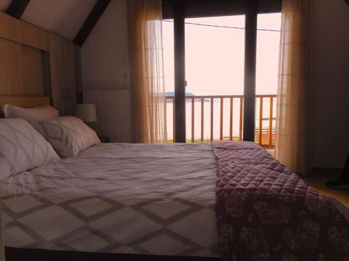 MikrolímniThe Lake House的一间卧室设有一张床,享有阳台的景色