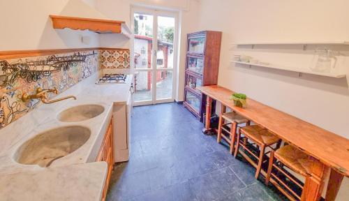 圣玛格丽塔-利古雷L'uliveto di Santa con piscina的厨房配有两个水槽和一个带椅子的柜台。