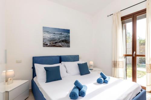 哥斯达雷Villa Sa Perda 3 - FREE WIFI - 500mt from the beach的一间卧室配有一张带蓝色枕头的大床