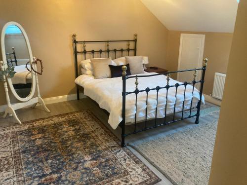 德罗赫达Alma’s retreat的一间卧室配有一张带镜子和地毯的床
