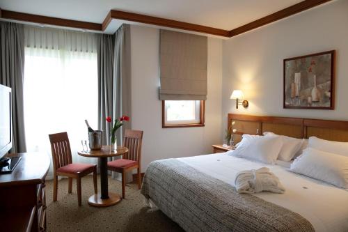 普耶韦普耶韦温泉康体Spa度假村的酒店客房带一张床、一张桌子和椅子