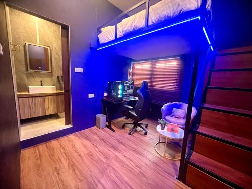 新加坡Arena eSports Hotel @ Bugis Village的一间卧室配有一张双层床、一张桌子和一台电脑