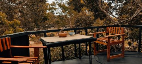 Bundala LevagamgodaJungle Cabin的阳台配有一张桌子和两把椅子