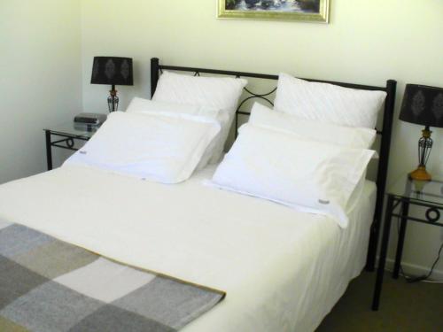 格伦因尼斯格伦瓦维利农家乐的一间卧室配有带白色床单和枕头的床。