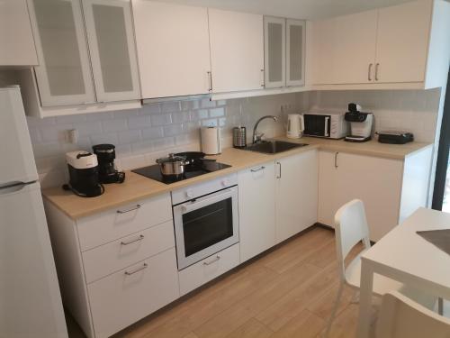 雅典S & K Apartment free indoor parking的白色的厨房配有白色的橱柜和桌子