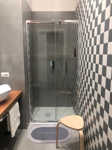 那不勒斯Dimora del Bosco的浴室设有玻璃门和凳子淋浴
