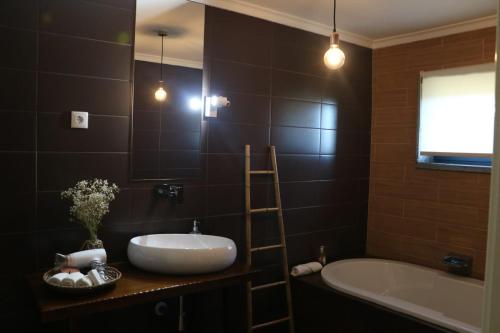 福什科阿新镇Eira da Fraga的一间带水槽、浴缸和镜子的浴室