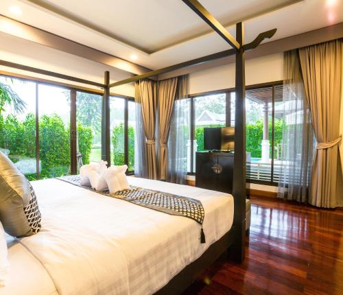 奥南海滩Pimann Buri Pool Villas Ao Nang Krabi Sha Plus的一间卧室设有一张大床和一个大窗户