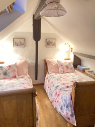 福维莱尔斯la Bodangeoise gîte rural的阁楼上的卧室配有两张床