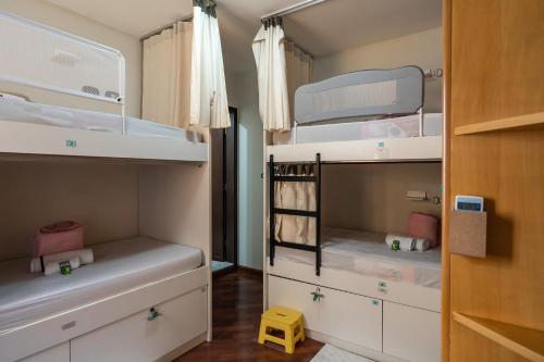 圣保罗圣保罗住宿加早餐旅舍的小房间设有白色双层床和黄色凳子