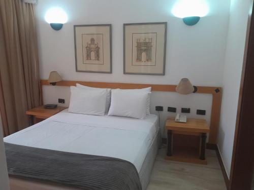 巴西利亚Bonaparte Hotel Residence - Suite 803的卧室配有白色的床和2个床头柜