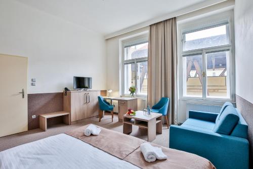 布拉格Apartments Embassy by LH的酒店客房,配有一张床和一张蓝色椅子
