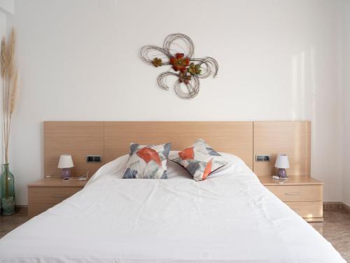 利乌玛Villa Victor的卧室配有带枕头和吊灯的白色床。