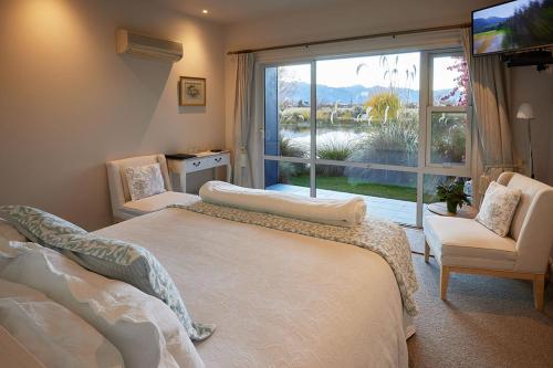 特威泽尔Matuka Lodge的一间卧室设有两张床和大窗户