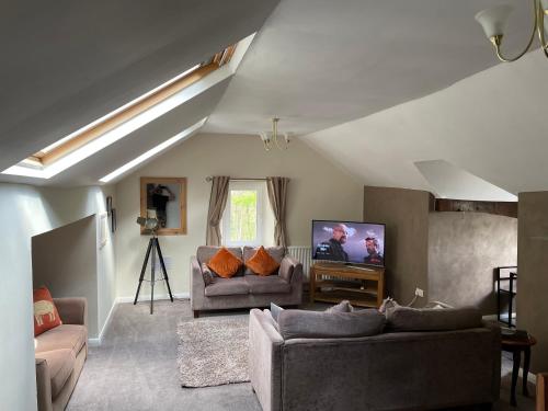 马特洛克Danbury Lodge Penthouse的客厅配有2张沙发和1台平面电视