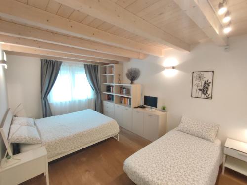 的里雅斯特Casa Vacanze Barcola的一间卧室设有两张床和窗户。
