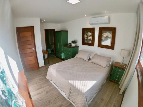 巴拉格兰德Apartamento na Vila de Barra Grande - Bahia的一间卧室配有一张大床和绿色橱柜。