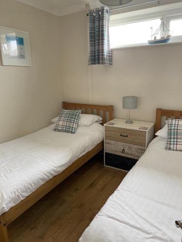 佩伦波斯Dunes View - Atlantic Bay的带窗户的客房内设有两张单人床。