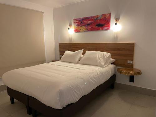 卡萨布兰卡Cabañas Pachamama Casablanca的卧室配有一张白色的大床和一张桌子