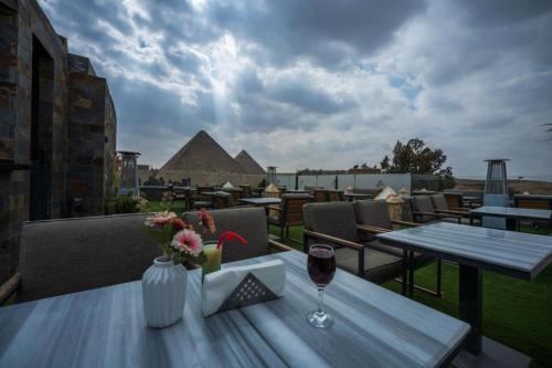 开罗Elite Pyramids Boutique Hotel的阳台上的桌子上放着一杯葡萄酒